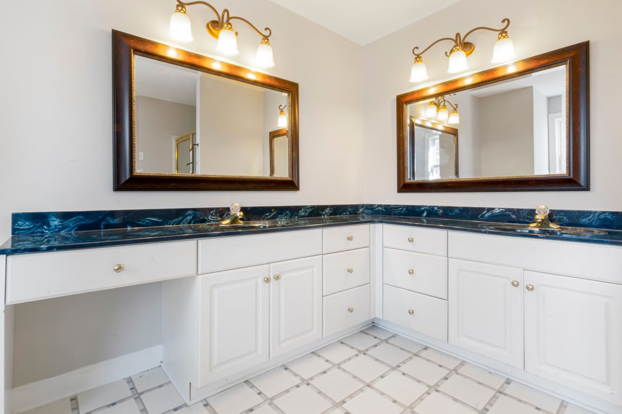 testimonial-img Spacious bathroom with dual mirrors, elegant lighting, and modern countertop design.