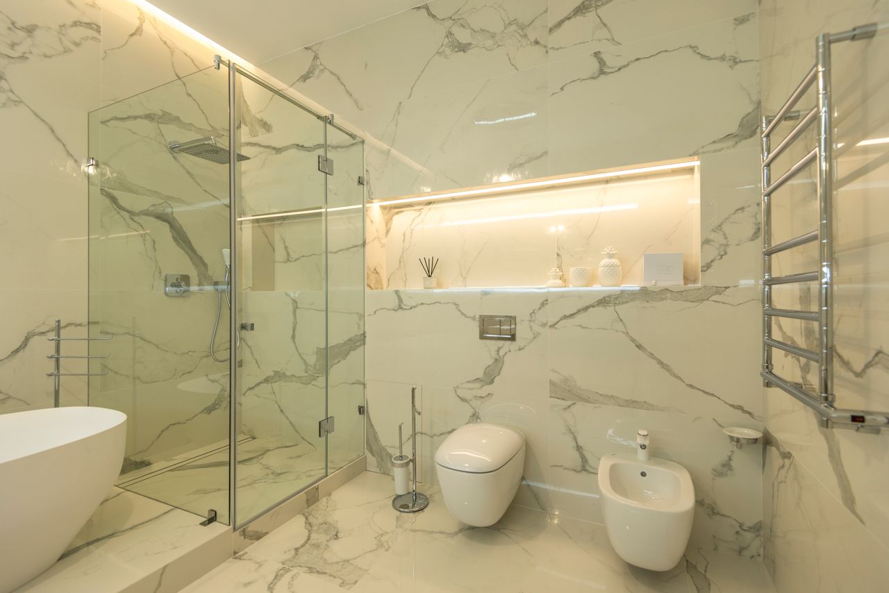 The Art of Drawing Readers In: Your attractive post title goes here Elegant luxury bathroom featuring marble walls, a glass shower, and modern fixtures.